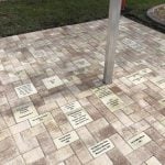 Engraved brick pavers around the pole